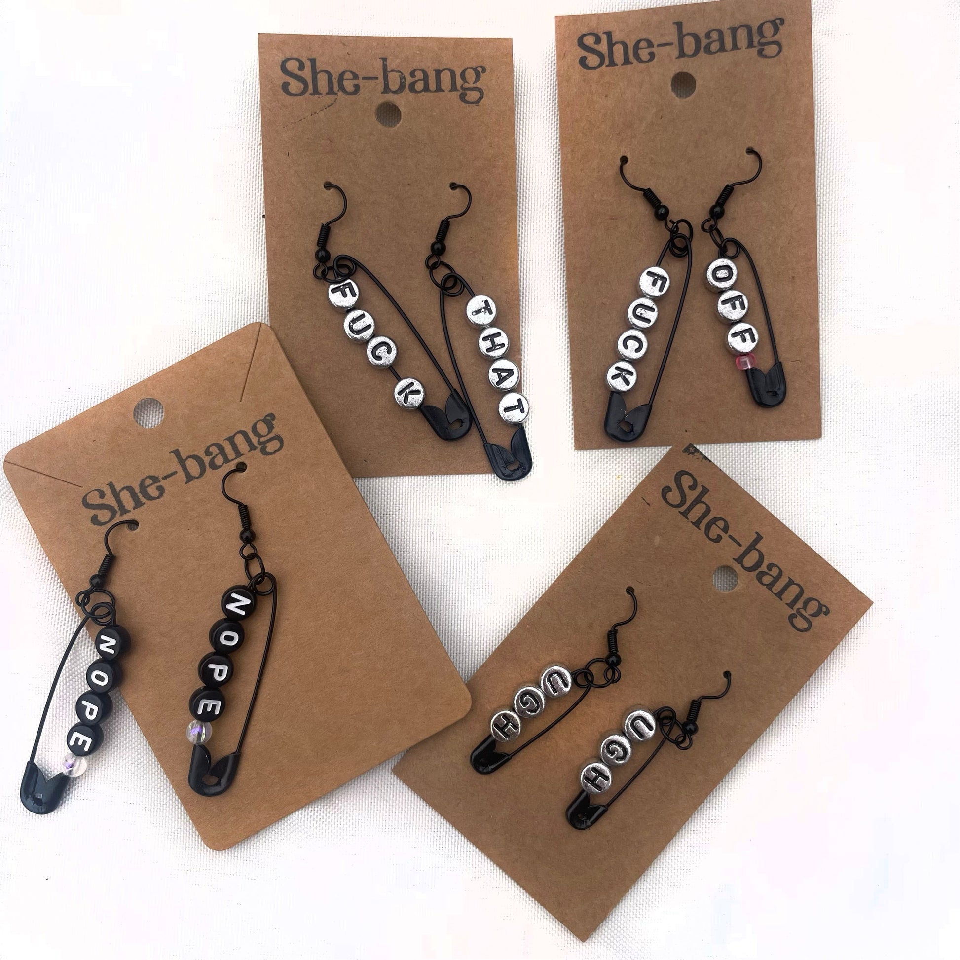 handmade safety pin earrings with profanity sayings.